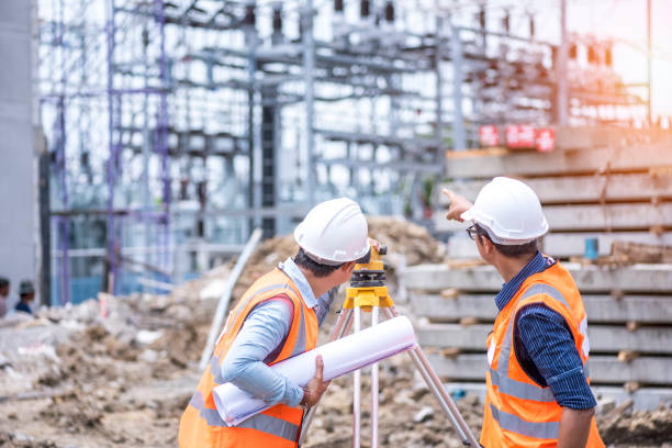 Civil Engineers At Construction Site and A land surveyor using an altimeter at construction site